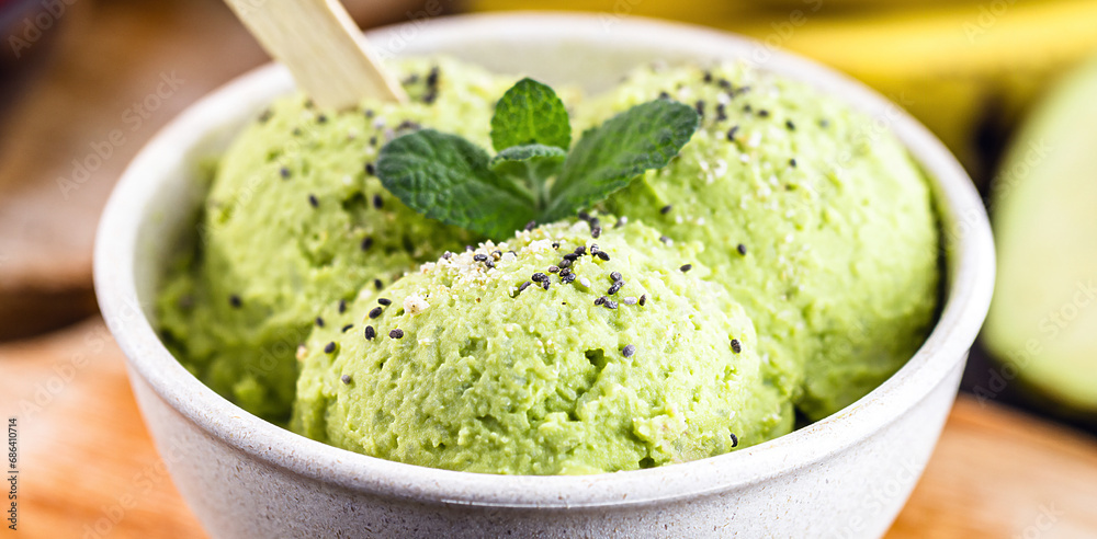 Homemade organic green avocado ice cream ready to eat, with mint leaf decorating. Homemade organic green avocado ice cream ready to eat, with mint leaf decorating.