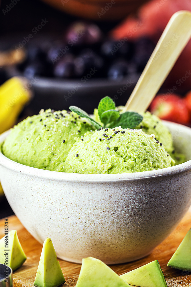 Homemade organic green avocado ice cream ready to eat, with mint leaf decorating. Homemade organic green avocado ice cream ready to eat, with mint leaf decorating.