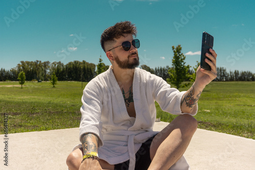 Fototapeta Naklejka Na Ścianę i Meble -  handsome young man in robe taking a selfie