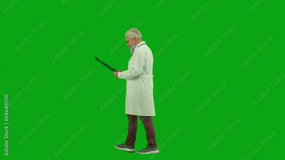 Portrait of aged man medic on chroma key green screen. Side view senior doctor walking through clinic or hospital looking at x-ray picture. Portrait of aged man medic on chroma key green screen. Side view senior doctor walking through clinic or hospital looking at x-ray picture.