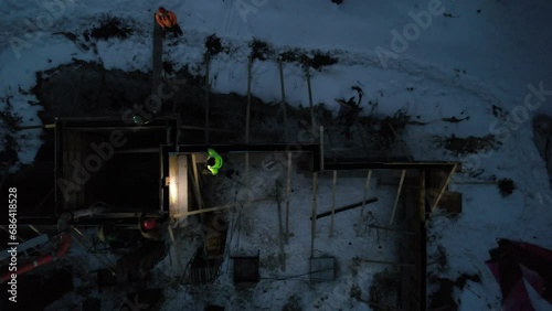 Aerial view of workers adding walls to a foundation