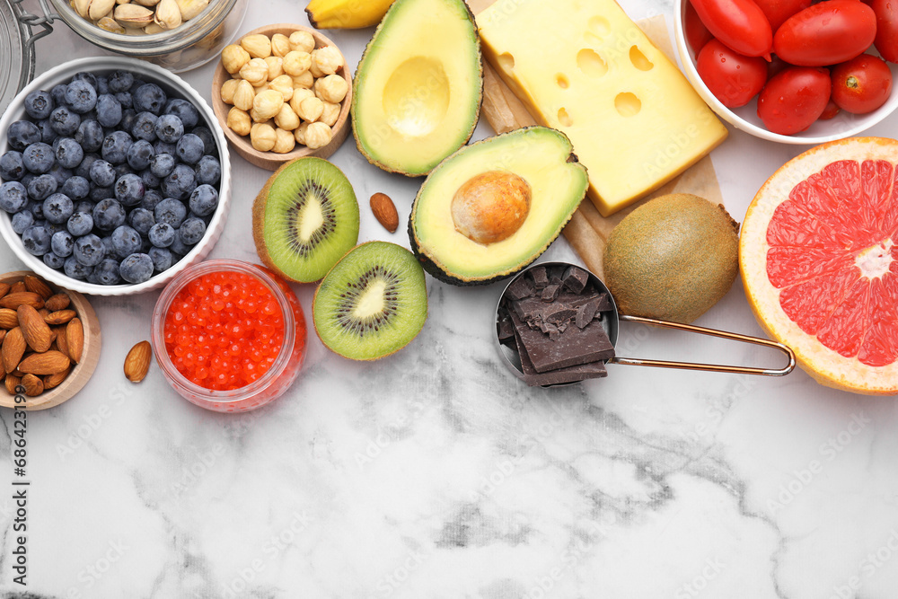 Many different products on white marble table, flat lay and space for text. Natural sources of serotonin Many different products on white marble table, flat lay and space for text. Natural sources of serotonin