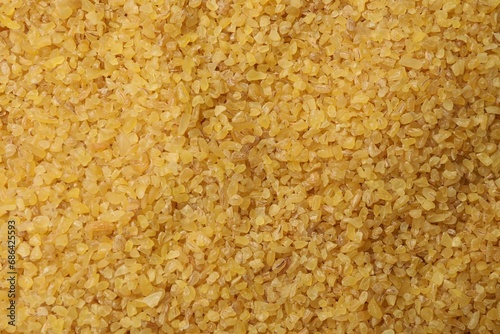 Pile of raw bulgur as background, top view