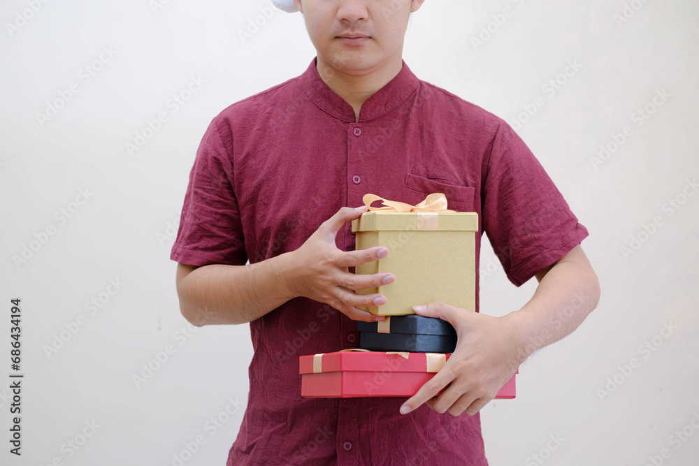 Male hands holding small gift boxes wrapped with gold ribbon. Isolated white background. Selective focus. Christmas Concept. Male hands holding small gift boxes wrapped with gold ribbon. Isolated white background. Selective focus. Christmas Concept.