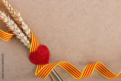 Flag of Catalonia. Celebration of the Catalan festivity, with three ears of wheat, a ribbon with the flag of Catalonia and a red glitter heart. Diada de Catalunya	