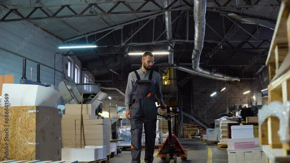 Warehouse worker with hand forklift truck at print factory Warehouse worker with hand forklift truck at print factory