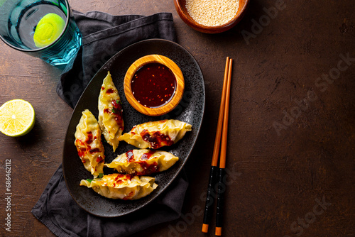 Asian dumplings with hot sauce on the dark background top view copy space for etxt photo