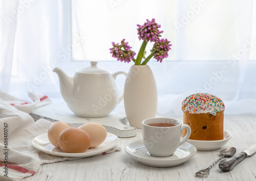 Easter still life with painted eggs  Easter cake and tea in a cup on the windowsill on a sunny day