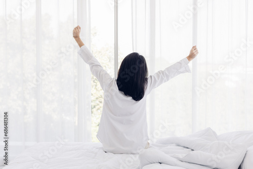 Woman stretching in bed after wake up. stretching and happy woman waking up in the morning after sleep, rest and relax at home.
