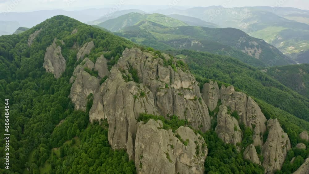 Drone retreating and revealing the expanse of the rock phenomenon Karadzhov Kamak, one of the peaks of the famous energy triad, in Northern Rhodopes in Central Bulgaria. Drone retreating and revealing the expanse of the rock phenomenon Karadzhov Kamak, one of the peaks of the famous energy triad, in Northern Rhodopes in Central Bulgaria.