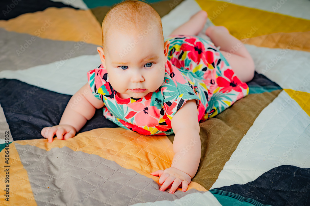 Obraz premium Portrait of a cute baby girl with blue eyes in colorful dress