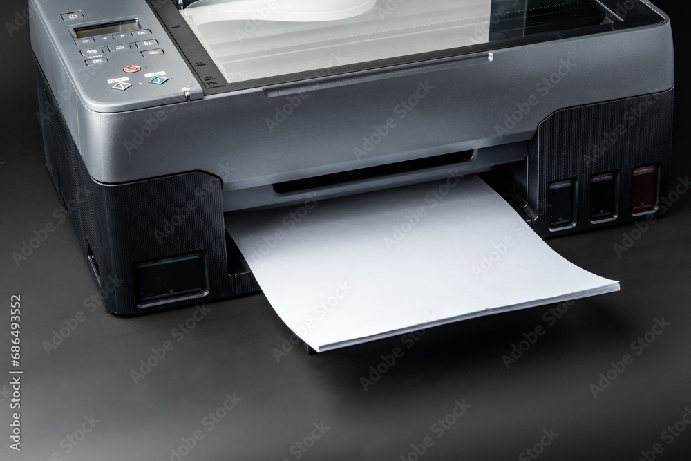 Modern laser printer on black background close up Modern laser printer on black background close up
