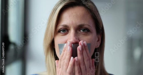 Woman is taping and sealing mouth photo