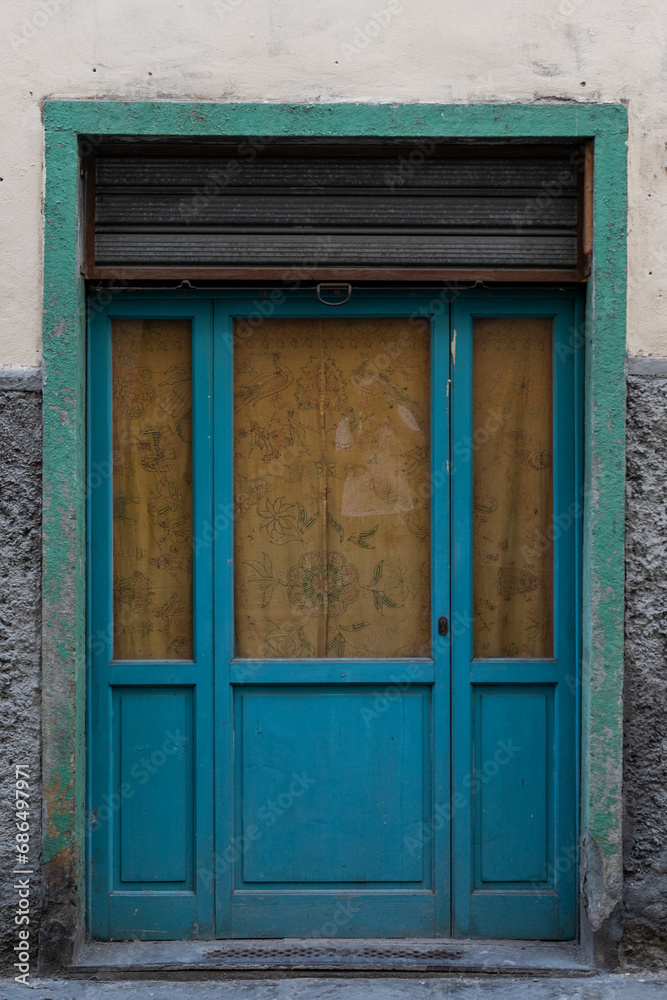 Old blue door with glass windows and green frame