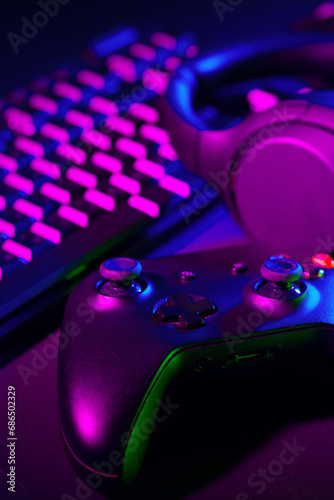 Headphones, joystick and computer keyboard on black table