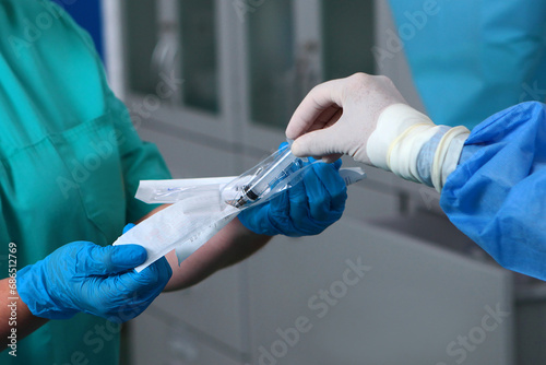 The syringe is in the hands of doctors. Modern surgery. The work of doctors in the operating room. close-up. photo