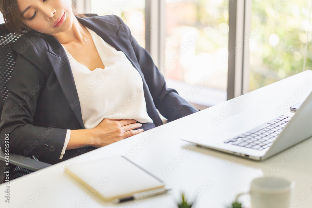 Woman with stomach pain feeling unwell sitting in office, Unhealthy office woman with stomach ache Woman with stomach pain feeling unwell sitting in office, Unhealthy office woman with stomach ache