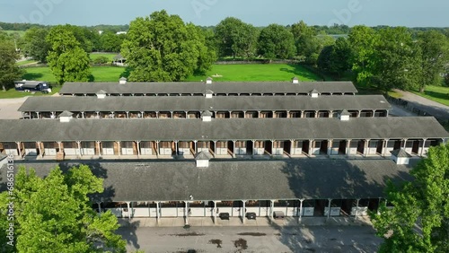 Aerial view of a long stable complex at Kentucky Horse Park, with lush greenery surrounding. photo