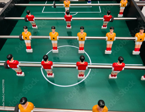 Fototapeta Naklejka Na Ścianę i Meble -  Football - board game with players, soccer ball and green field. Foosball table, close-up.