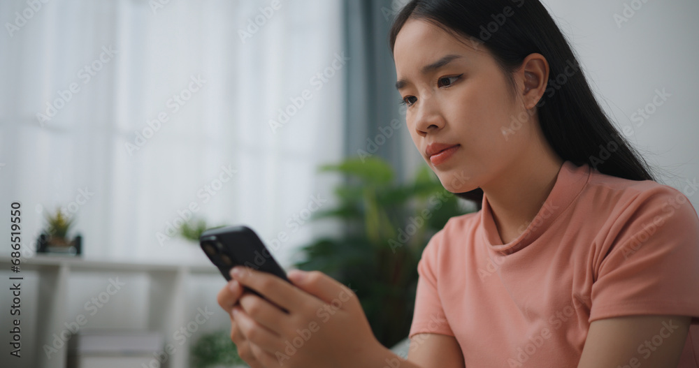Portrait of Happy young asian woman relax on comfortable couch at home shopping online on smartphone, smiling girl use cell phone chatting, browse wireless internet on gadget Portrait of Happy young asian woman relax on comfortable couch at home shopping online on smartphone, smiling girl use cell phone chatting, browse wireless internet on gadget