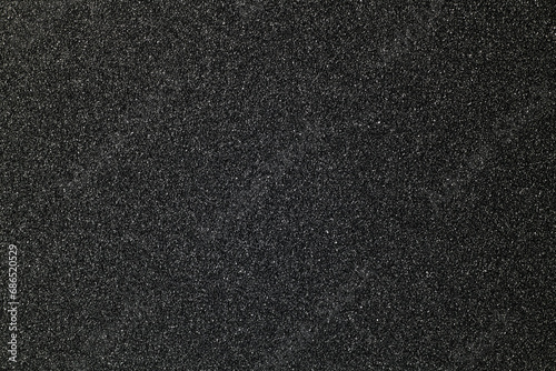 black sandpaper texture background, close-up