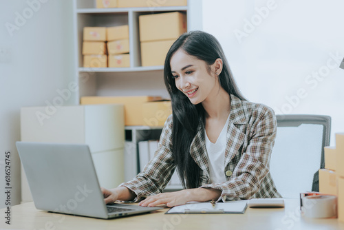 Small business entrepreneur or independent Asian woman holding a parcel box Young successful Asian woman with her packaging boxes, online marketing and shipping.