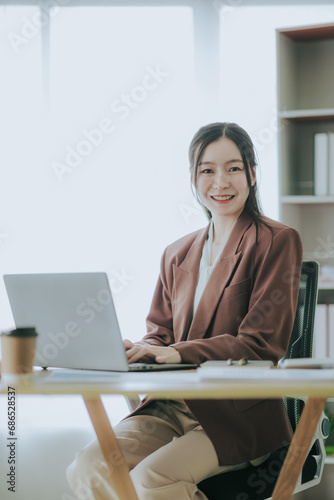 Attractive Asian woman working at office using laptop