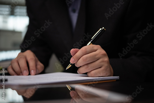 man hands with pen writing paperwork Planning taxes and finance for investment