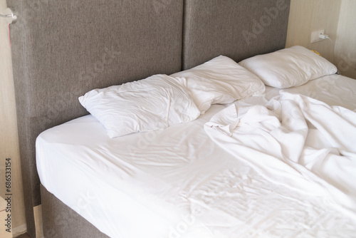 Sunlit bed sheets  tousled from sleep  evoke tranquility. Resonates with themes of restfulness in interior design trends.