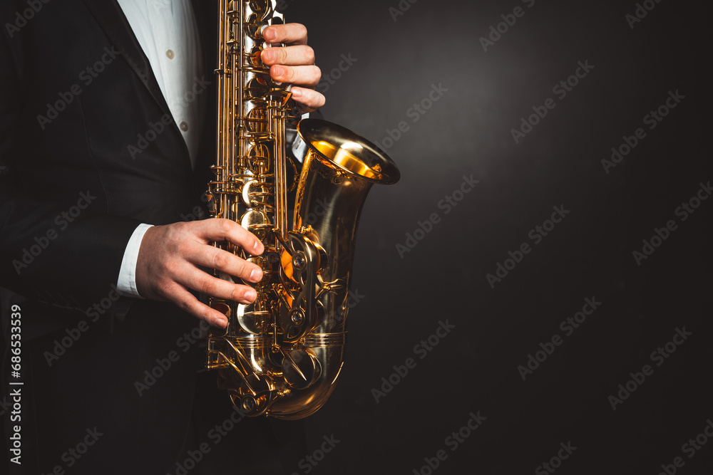 Naklejka premium skilled hands of men play saxophone, capturing essence of musical expression and talent. close-up shot against black background. High quality photo