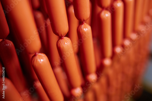 Appetizing sausages on racks in a sausage shop. Sausage production.