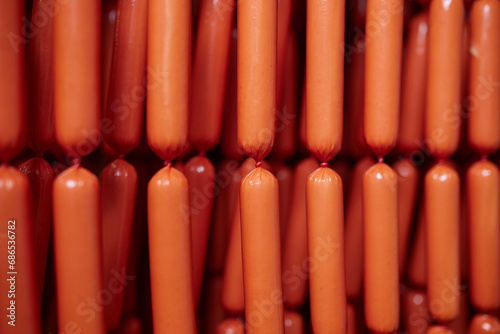 Appetizing sausages on racks in a sausage shop. Sausage production.
