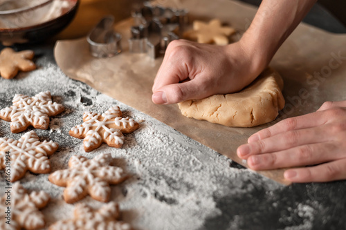 Traditional Christmas homemade cookie baking. Man's hands kneading dough on table with flour and gingersnaps. Soft selective focus, lifestyle photo