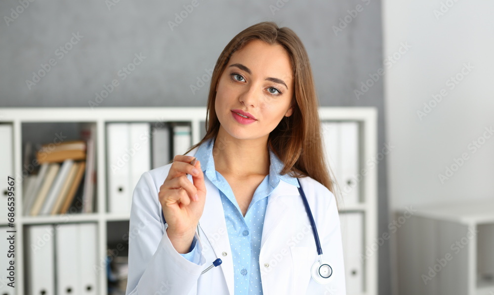 Portrait of beautiful woman doctor holding pen. Medical insurance contract concept Portrait of beautiful woman doctor holding pen. Medical insurance contract concept
