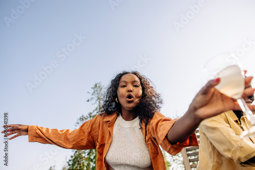 Low angle view of woman dancing with friend during dinner party photo