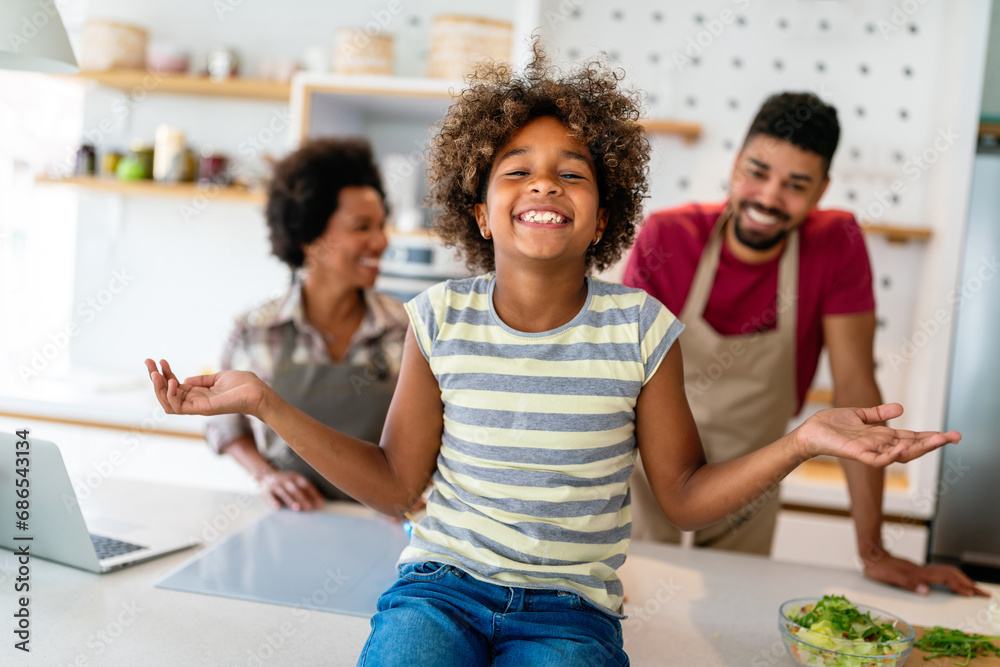 Happy african american parents and child having fun preparing healthy food in kitchen Happy african american parents and child having fun preparing healthy food in kitchen