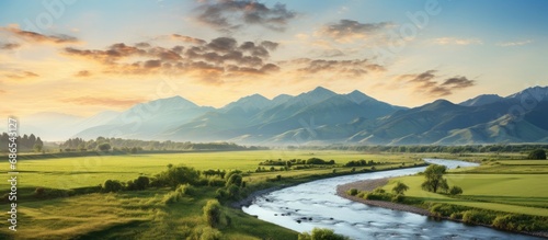 Distant mountain with river and open field at sunrise. © AkuAku