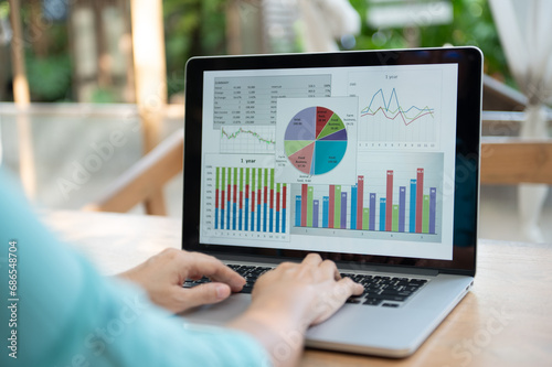 Business analytics concept. Analyst using laptop with graph and chart screen with financial dashboard template for statistical study of business data. photo