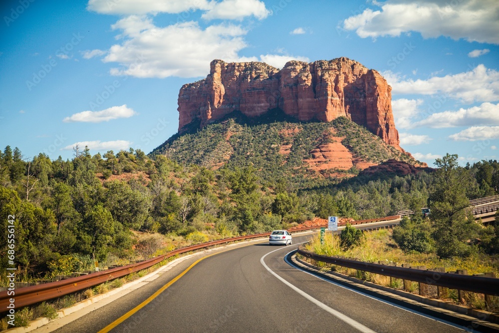 Picturesque road winding through lush, green mountains with abundant foliage in Sedona, Arizona.