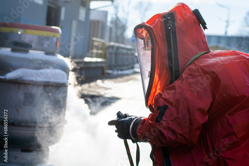 Firefighters in protective chemical HAZMAT suits stop the leak of the dangerous substance ethylene oxide from the tank