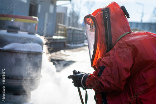 Foto Firefighters in protective chemical HAZMAT suits stop the leak of the dangerous