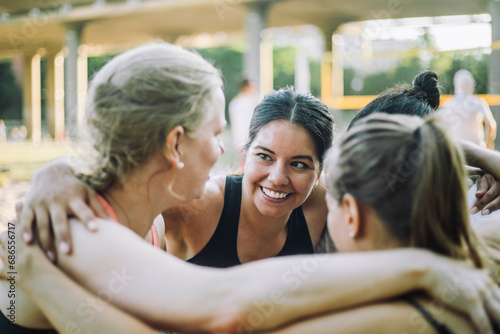 Smiling woman huddling with female friends photo