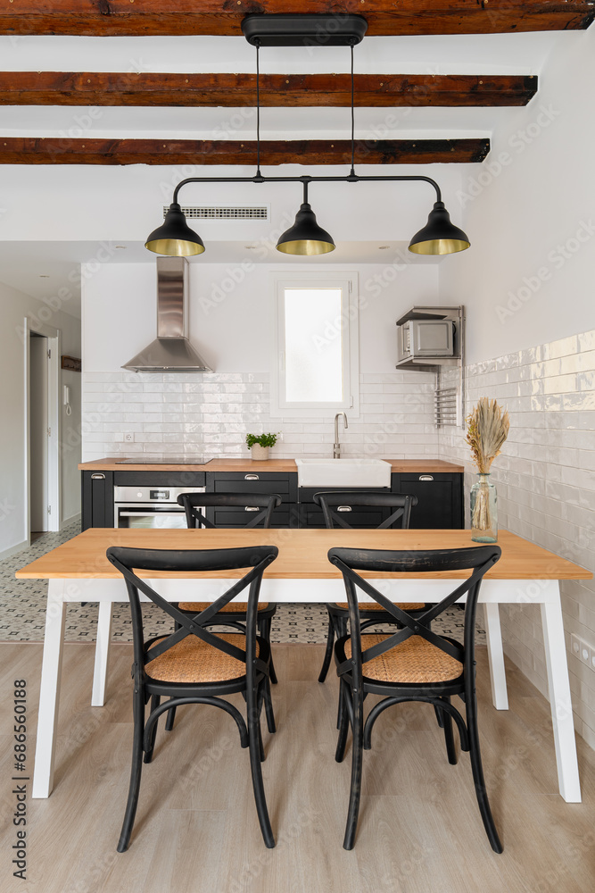 Fototapeta premium Dining table under vintage chandelier in studio apartment