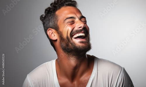 Vibrant Portrait of a Joyful Middle-Eastern Man Laughing with Eyes Closed, Wearing a White Shirt on a Plain Background