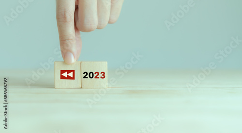 2023 Recap economy, business, financial summary, business review concept. For business planning in 2024. Replay icon and 2023 on wooden cubes on smart grey background and copy space.