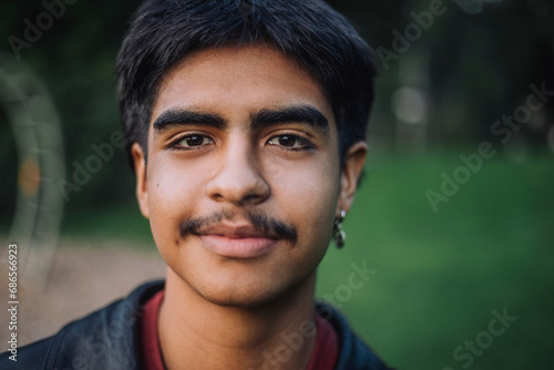 Portrait of smiling teenage boy with mustache photo
