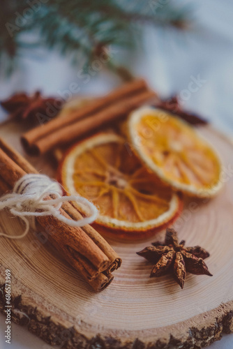 Christmas decoration with dried orange slices, cinnamon sticks and star anise on wooden plate