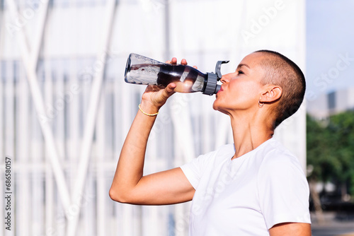 happy young sports woman drinking water during training, concept of healthy and active lifestyle, copy space for text