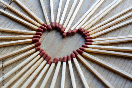 Heart made from matches on the wooden background. Many long matches in heart form for men