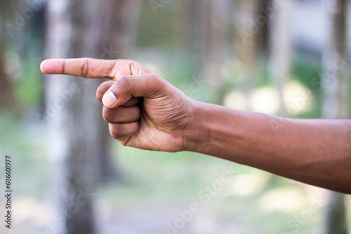 A man pointing one finger of his hand forward and blurred background © Rokonuzzamnan